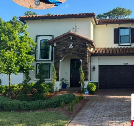 A two-story stucco and stone home after an exterior wash