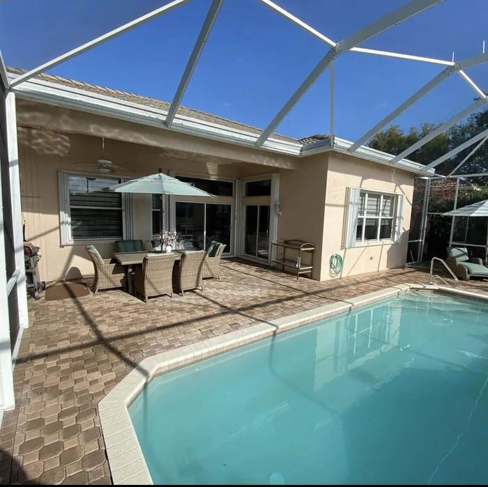 A paver pool deck under a screen enclosure, freshly cleaned